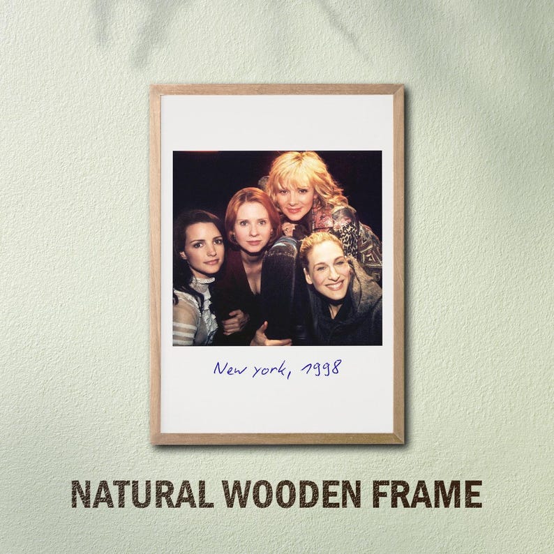May include: A framed print featuring a group of four women, with the text "New York, 1998" in a handwritten style. The frame is made of natural wood, and the words "NATURAL WOODEN FRAME" are printed at the bottom.