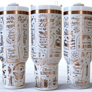 May include: White insulated tumbler with a handle, featuring gold and black text and illustrations related to teaching. The design includes phrases like "Teach, Love, Inspire" and "Teacher Life," along with images of books, apples, and butterflies.