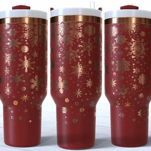 May include: Three red insulated tumblers with gold snowflake patterns. Each has a white lid, a copper band, and a red handle. These tumblers are designed for hot or cold drinks, ideal for festive occasions.