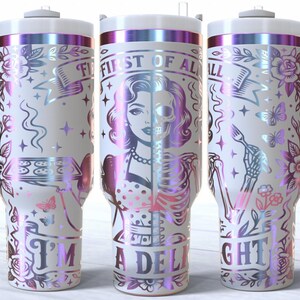 May include: White tumbler with a handle, featuring a design with a woman's face, half skull, and the text "FIRST OF ALL I'M A DELIGHT". The design includes flowers, butterflies, and a skeleton hand holding a fork, with iridescent accents.