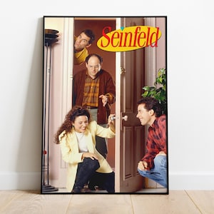 Könnte beinhalten: Ein gerahmtes Poster mit den Darstellern der Sitcom "Seinfeld". Das Bild zeigt vier Charaktere in einer Tür, mit dem Logo der Show in Gelb und Rot. Die Schauspieler tragen verschiedene Outfits, darunter einen gelben Blazer und ein kariertes Hemd.