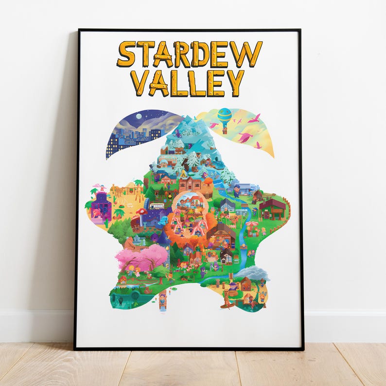 Op de afbeelding: Een ingelijste poster met de woorden "STARDEW VALLEY" in geel, omlijnd in zwart. De poster toont een kleurrijke kaart van een vallei met gebouwen, bomen en een rivier. De kaart heeft de vorm van een ster, tegen een witte achtergrond.