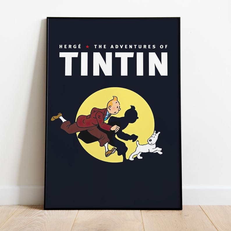 May include: A framed poster featuring the text "HERG&Eacute; THE ADVENTURES OF TINTIN" above an illustration of Tintin, his shadow, and Snowy running in front of a yellow circle against a dark blue background.