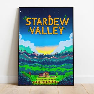 Op de afbeelding: Een ingelijste poster met de tekst "STARDEW VALLEY" in het geel. De afbeelding toont een zonsondergang boven bergen, een huis en een veld met zonnebloemen, tegen een blauwe lucht. De lijst is zwart.