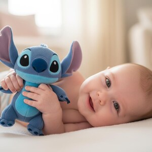 May include: A plush blue Stitch doll with large ears and big eyes is held by a baby. The baby is smiling and looking at the camera. The doll is a popular character from the Disney movie Lilo & Stitch.