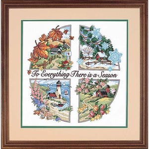 May include: A framed cross-stitch embroidery featuring four quadrants representing the seasons, with a central text reading "To Everything There is a Season." The artwork displays autumn leaves, winter snowflakes, a coastal lighthouse, and spring flowers.