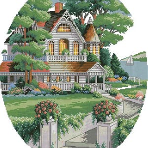 May include: A cross-stitch pattern featuring a white house with a porch, a balcony, and a turret. The scene includes a green lawn, flower-filled stone pillars, lush trees, and a distant lake with a sailboat, all set within an oval frame.