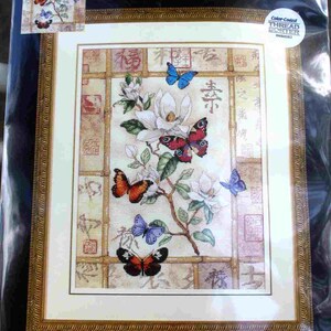 Puede incluir: Un kit de punto de cruz contado Dimensions Gold Collection titulado Brilliant Butterfly Celebration. El paquete muestra un diseño terminado de flores de magnolia blancas y mariposas coloridas sobre un marco de bambú, que mide 30 cm por 41 cm.