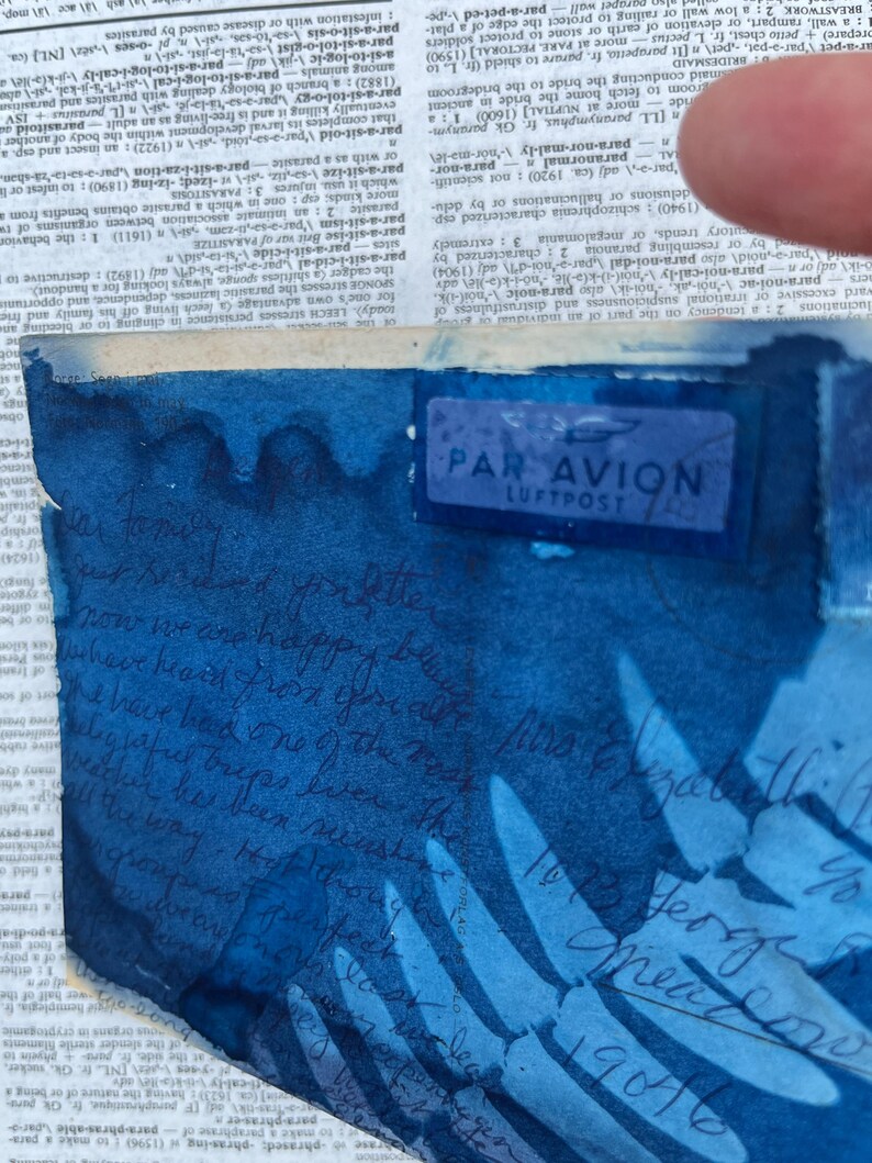 May include: A blue and white envelope with a "Par Avion Luftpost" stamp. The envelope has a blue watercolour wash and handwritten text in black ink.