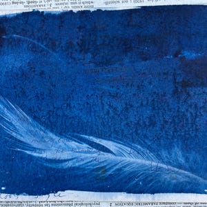 May include: A cyan blue background with a white feather in the bottom right corner. The feather is partially obscured by the blue background. The image has a vintage, faded look.