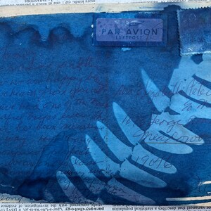 May include: A blue and white postcard with a stamp that says "PAR AVION LUFTPOST" and a handwritten message in blue ink. The message says "Dear George, I hope you are well. We have had a lot of rain. The birds are back in the nest. We have had a few nice days. I hope you are well.  Sincerely,  Meadow 19016"