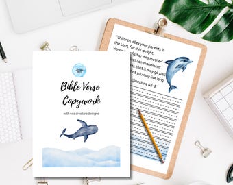 May include: Bible verse copywork with sea creature designs. The image shows two pages, one with text and a dolphin illustration, and the other with the text "Bible Verse Copywork" and a dolphin illustration. A pencil and a clipboard are also visible.