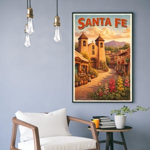May include: A framed art print featuring a vibrant illustration of Santa Fe, New Mexico. The artwork depicts a church, a cobblestone street, and colorful flowers. The text "SANTA FE" is displayed at the top.