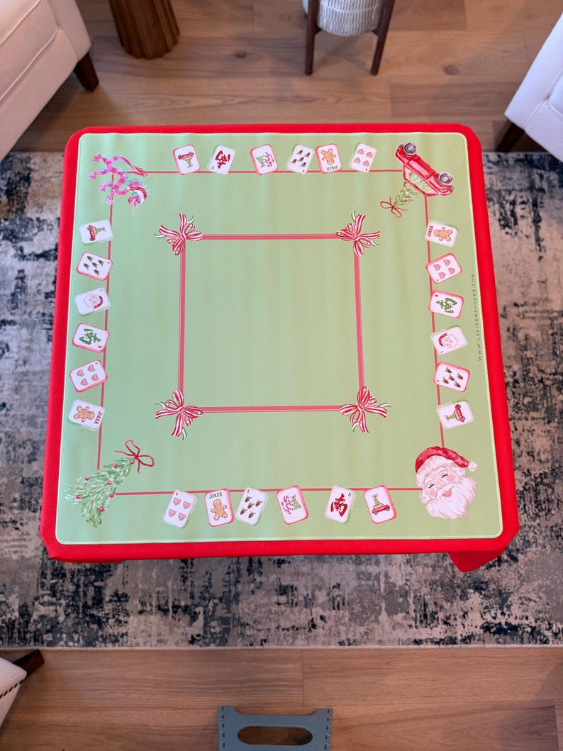 May include: A festive Christmas table cover with a light green central area and a red border. The cover is decorated with illustrations of Santa Claus, gingerbread men, and bows. Designed for a square table, it adds a seasonal touch.