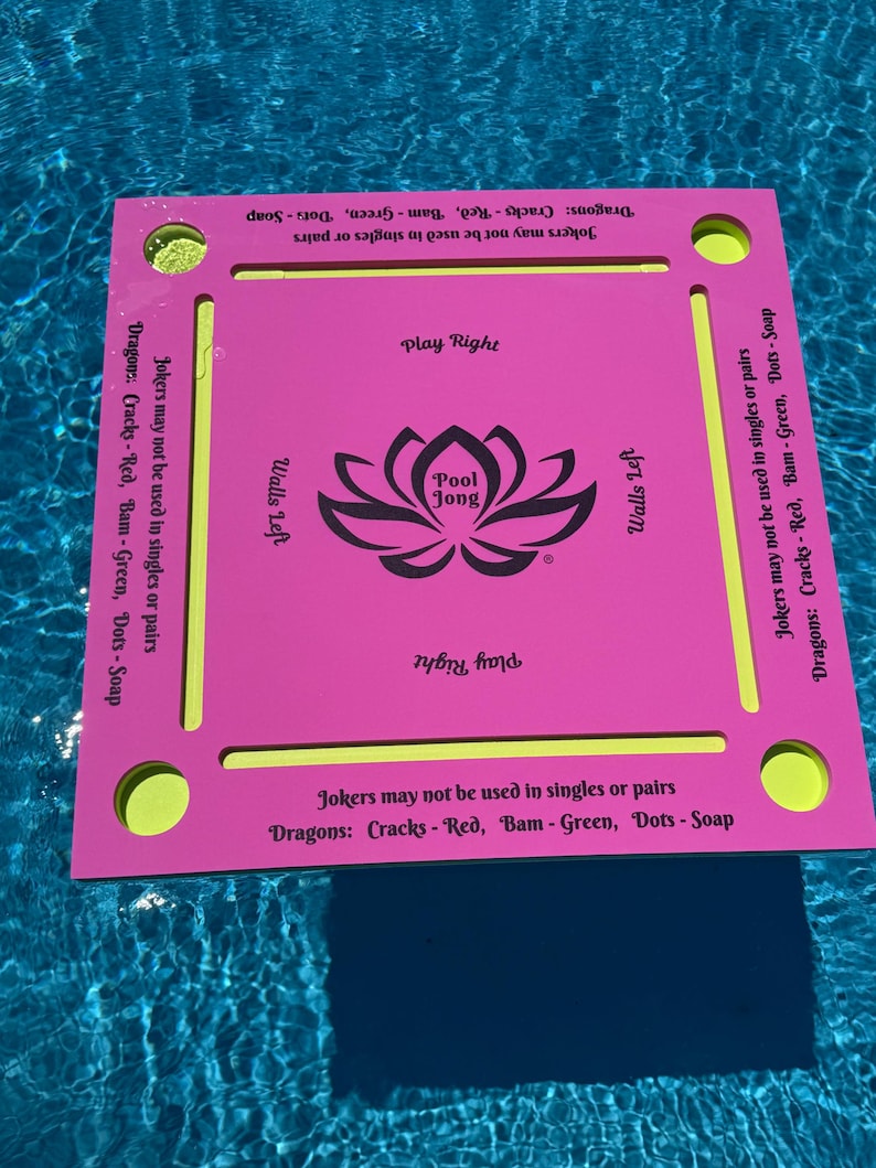 May include: A square pink floating game board with yellow accents and four corner circular cutouts. The center features a black lotus graphic with the text Pool Jong. Text on the edges includes Play Right, Walls Left, and game rules for Jokers and Dragons.