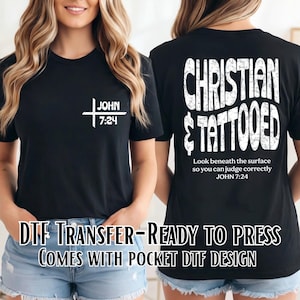 May include: A black t-shirt featuring a white graphic on the front left chest that reads "JOHN 7:24" with a cross symbol. The back of the shirt displays the text "CHRISTIAN & TATTOOED" in a large, distressed white font above "Look beneath the surface so you can judge correctly JOHN 7:24".