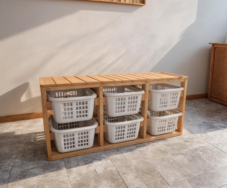 Pu&ograve; includere: Un mobile contenitore in legno con sei scomparti, ciascuno con un cestino di plastica bianco. L'unit&agrave; ha un piano a doghe e una finitura in legno naturale. Ideale per organizzare il bucato o altri oggetti per la casa.