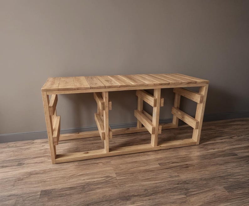 Pu&ograve; includere: Una consolle in legno chiaro con piano a doghe e base geometrica. Il tavolo &egrave; realizzato in legno naturale e ha una forma rettangolare. Il tavolo misura circa 152 cm di lunghezza, 41 cm di larghezza e 76 cm di altezza.