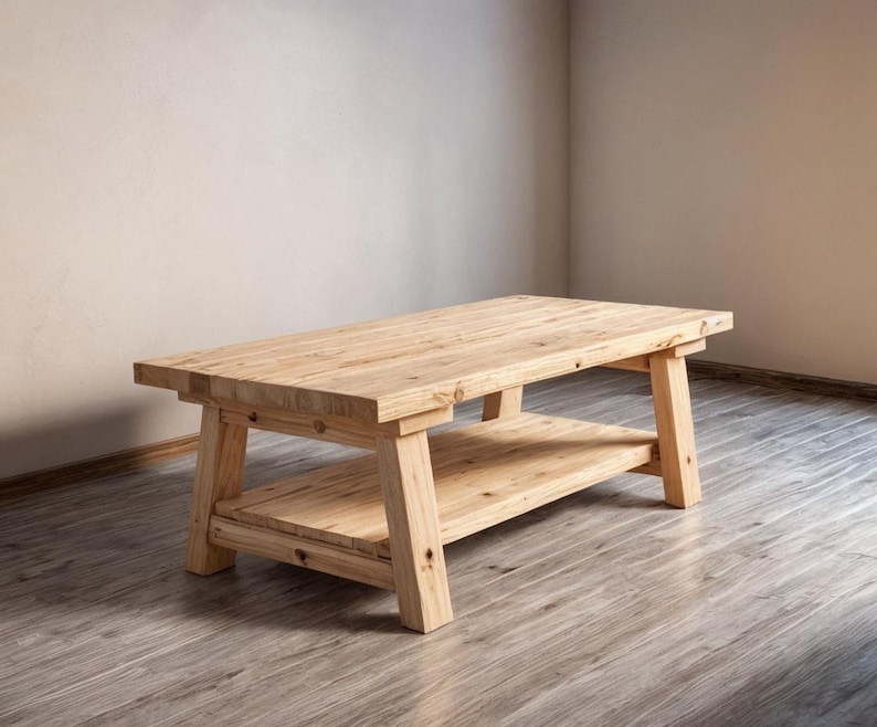 May include: A rectangular, light-colored wooden coffee table with a lower shelf. The table has a natural wood grain finish and sturdy, angled legs. The table measures approximately 48 inches long, 24 inches wide, and 18 inches high.