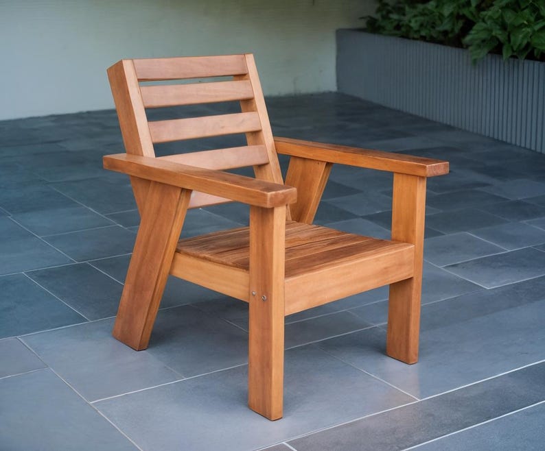 May include: A wooden armchair with a natural finish. The chair has a slatted back, armrests, and a seat made of wooden planks. The chair is constructed with visible joints and a sturdy frame, suitable for outdoor or indoor use.