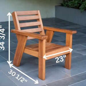 May include: A wooden outdoor chair with a natural finish. The chair has a slatted back, armrests, and a seat that is 58 cm wide. The chair is 88 cm high and 77.5 cm deep.