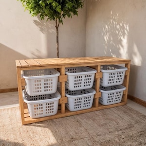 May include: A wooden storage unit with six white plastic baskets. The unit is made of light brown wood and has a slatted design. The baskets are rectangular with a grid pattern. A small tree is in the background.