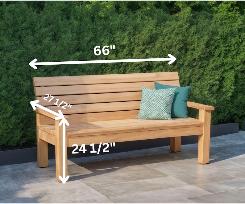 May include: A wooden outdoor bench with a natural finish. The bench is 66 inches long, 27.5 inches high, and 24.5 inches deep. Two decorative pillows in teal and patterned green are on the bench.