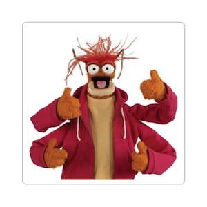 May include: A Muppet character with orange fur, wearing a red hooded sweatshirt over a tan sweater. The character has four arms, each with a thumbs-up gesture. The character's face has large eyes, a wide mouth, and red spiky hair.