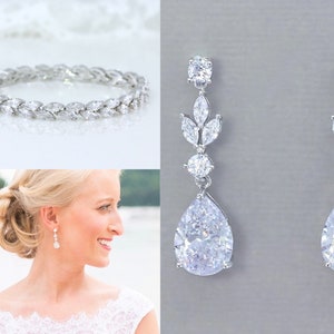 May include: A bridal jewelry set featuring a silver bracelet with clear cubic zirconia stones and a pair of silver teardrop earrings with clear cubic zirconia stones.