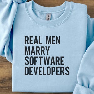 Light blue Gildan sweatshirt with "REAL MEN MARRY SOFTWARE DEVELOPERS" text.