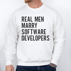 White sweatshirt with black text reading "REAL MEN MARRY SOFTWARE DEVELOPERS."