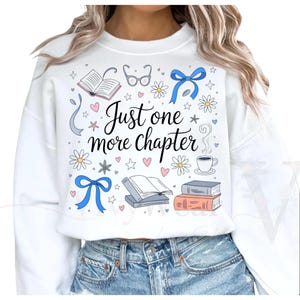 Könnte beinhalten: Weißes Sweatshirt mit einem Grafikdesign mit Büchern, Brillen, Blumen, Herzen und dem Text "Just one more chapter". Das Design umfasst blaue Schleifen und eine Kaffeetasse.