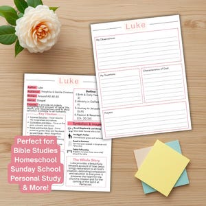 May include: Two printed study sheets titled Luke with pink headers, featuring sections for observations, questions, and characteristics of God. The sheets include an outline, key themes, and symbolism. A white flower and three square sticky notes are nearby.