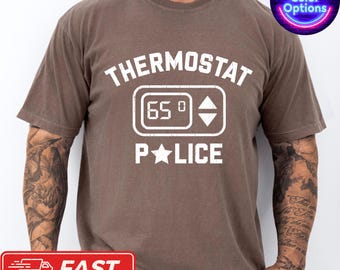 May include: Brown t-shirt with the words "THERMOSTAT POLICE" in white block letters. The design includes a thermostat graphic displaying "65°". A neon sign in the upper right corner says "More Color Options".