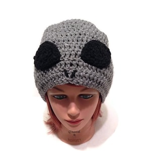 May include: Gray crocheted beanie with black crocheted alien eyes.