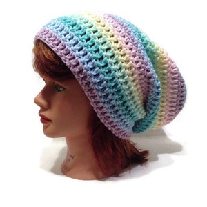 May include: A rainbow striped crochet beanie hat. The hat is made with a soft, colorful yarn and has a slouchy fit.