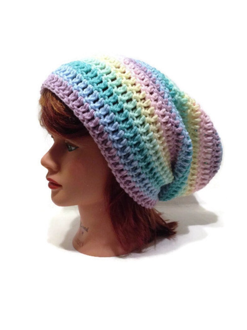 May include: A rainbow striped crochet beanie hat. The hat is made with a soft, colorful yarn and has a slouchy fit.