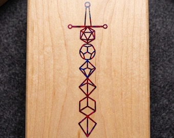 May include: A rectangular light-coloured wooden box featuring a centred inlay design of a sword. The sword is composed of a vertical stack of six geometric polyhedral shapes, rendered in a multi-coloured pattern of red, blue, and purple hues.