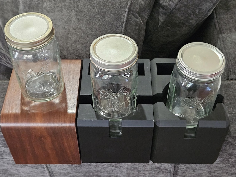 以下が含まれることがあります： 銀色の蓋が付いた、透明なガラス製のBallメイソンジャーが3つ。1つは湾曲した濃い色の木製スタンドに、他の2つは黒いホルダーに置かれています。ジャーは空で、すぐに使用できます。