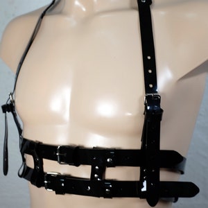 Product shot of a 2 story chest harness made from black PVC with high quality steel buckles and rivets showing close up details of the item