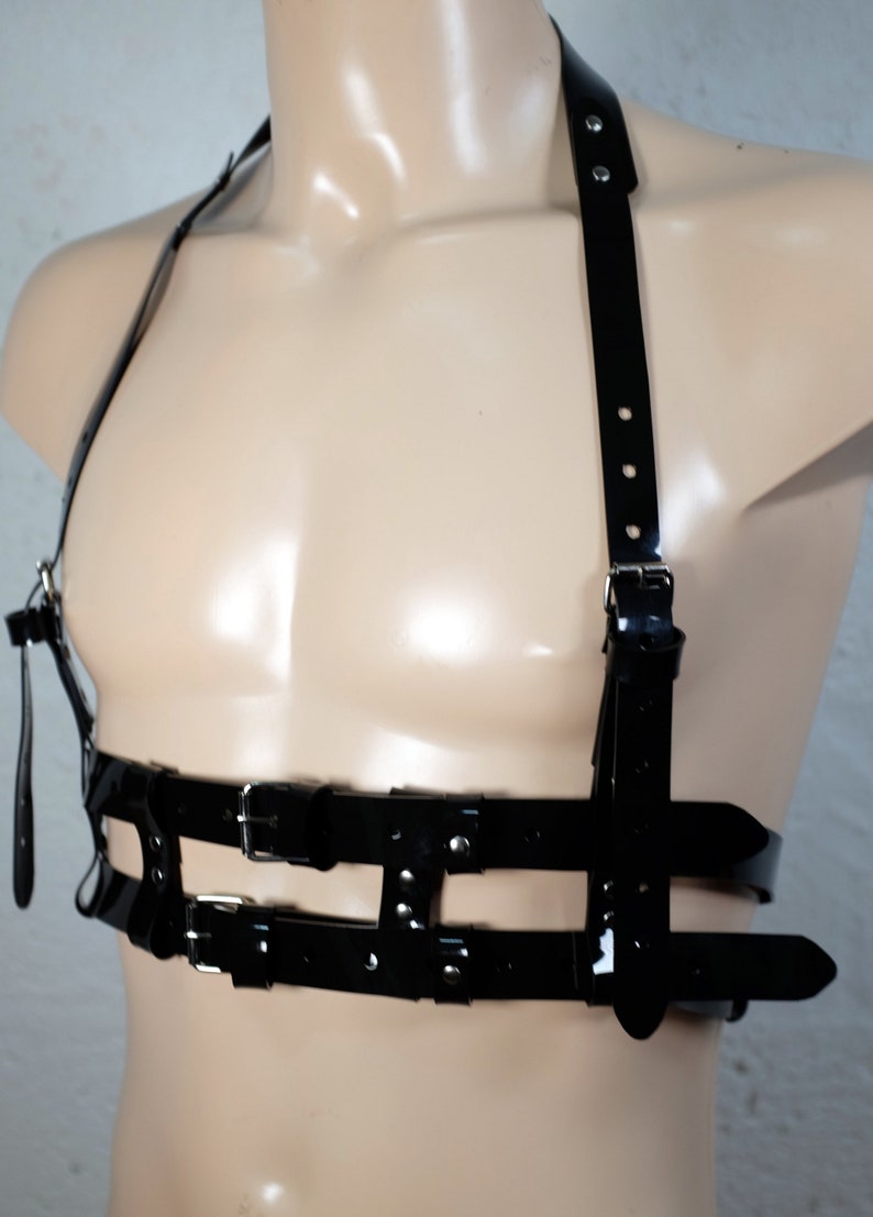 Product shot of a 2 story chest harness made from black PVC with high quality steel buckles and rivets showing close up details of the item