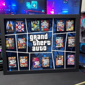 Puede incluir: Un marco rectangular negro tipo caja que contiene una colección de portadas de juegos Grand Theft Auto en miniatura dispuestas alrededor de un logotipo blanco central. El fondo presenta un diseño de mapa azul y negro con líneas blancas.