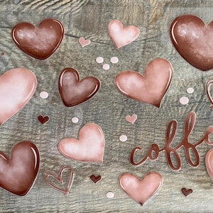 May include: A sheet of clear vinyl stickers with a pink and brown color scheme. The stickers feature hearts and the word "coffee" in a cursive font.
