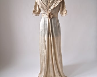 May include: A vintage ivory silk wedding dress with a lace bodice and a long flowing skirt.