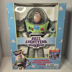 May include: Buzz Lightyear Ultimate Talking Action Figure in its original packaging. The figure is in a box with a blue background and white clouds. The figure is wearing a green and purple space suit with a clear helmet. The box reads "Buzz Lightyear".