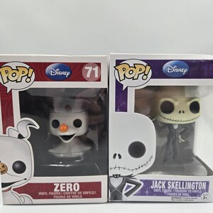 May include: Two Funko Pop vinyl figures in their original boxes. On the left, a Zero figure with a white ghost body and orange nose. On the right, a Jack Skellington figure wearing a black and white pinstripe suit. Both boxes feature Disney branding.