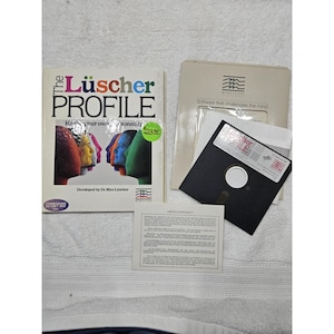 May include: A vintage computer software set titled "The Lüscher Profile." The set includes a book with colorful profile illustrations, a floppy disk, and a Mindscape software case. The book cover features the title in large, colorful letters.