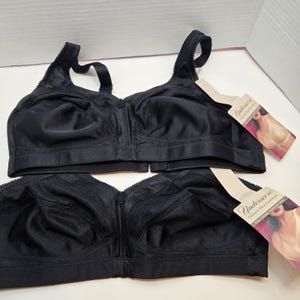 May include: Two black bras with front closures and adjustable straps. Each bra has a tag that reads "Underscore Fashion Plus Comfort". The bras are made of a smooth, solid fabric and are designed for comfort and support.