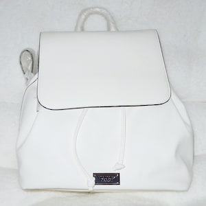 May include: White faux leather backpack with a drawstring closure and a small metal logo tag.