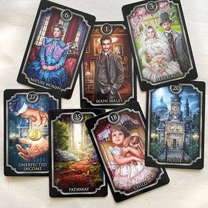 May include: A collection of tarot cards with black borders and silver accents. The cards feature illustrations of people, buildings, and scenes, with titles such as "Mature Woman," "Main Male," and "Marriage."